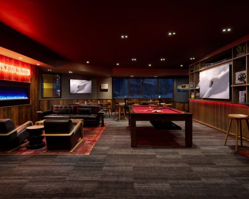elevation resort matchstick. An indoor lounge with couches, a pool table, and a lit up sign that says "ignite your purpose"