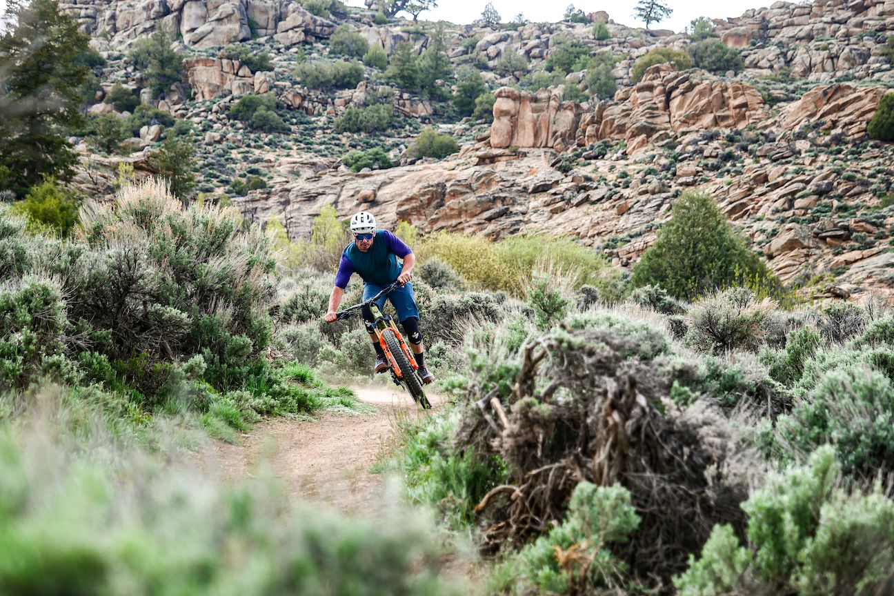 a man riding a mountain biking through a field of sagebrush
