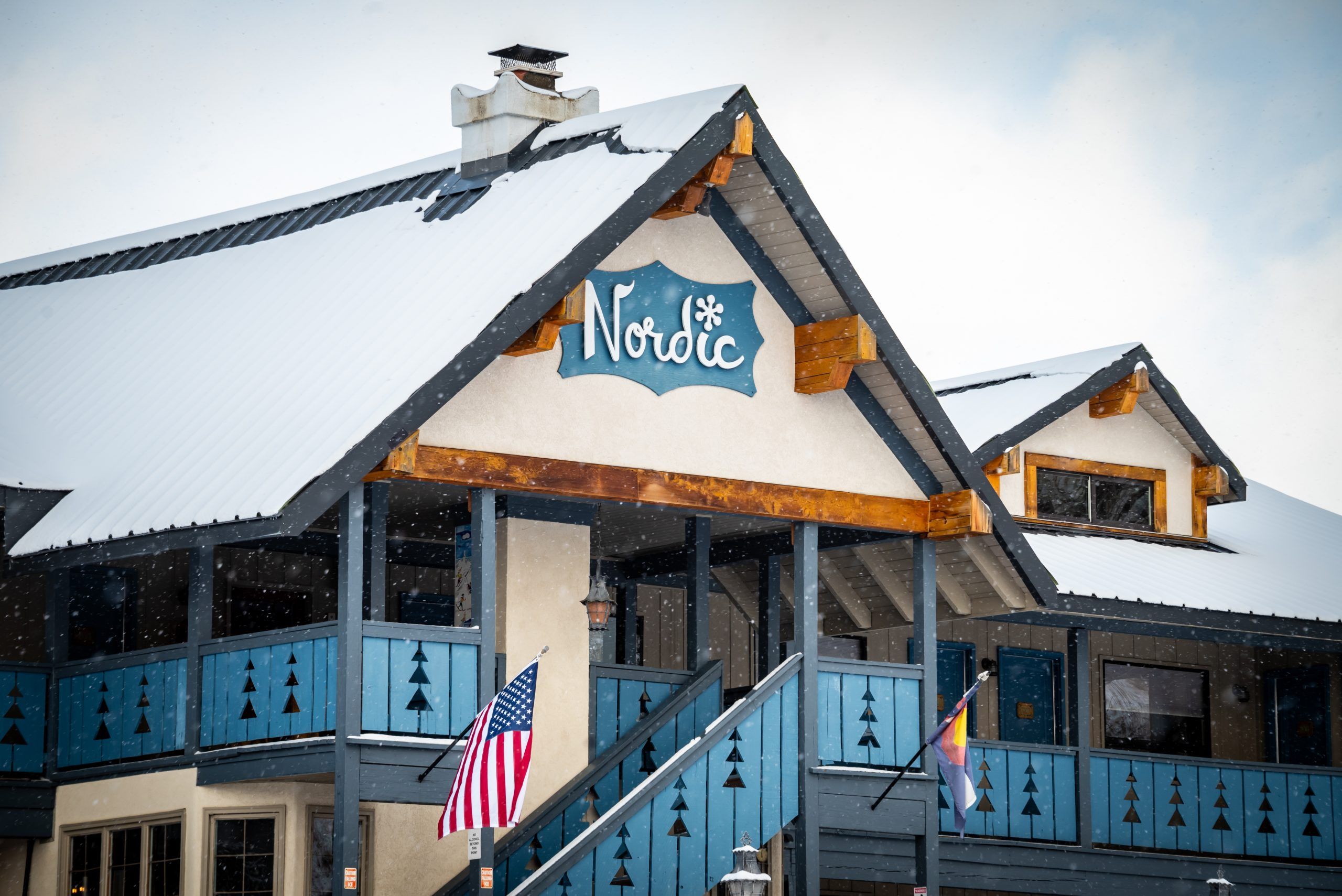 A Swiss-inspired hotel with a blue staircase. Snow blankets the roof. 