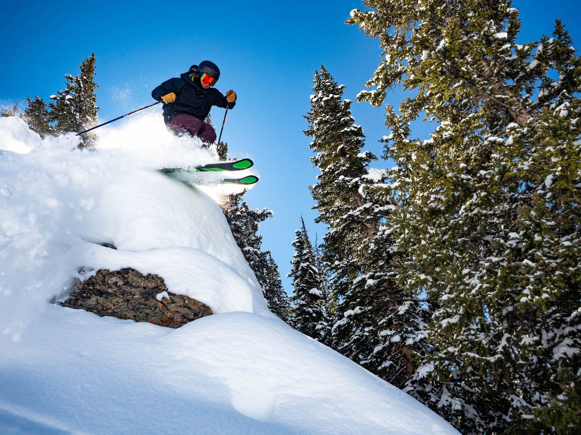 A skier skiing over a small cliff. Skiing extremes at Crested Butte Mountain Resort.