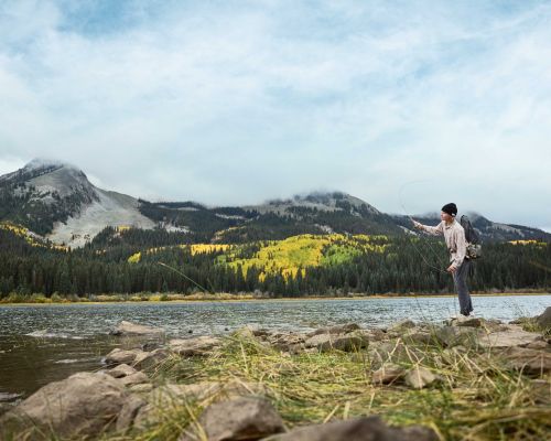 An angler casts into a small lake while fall fishing in Gunnison and Almont.