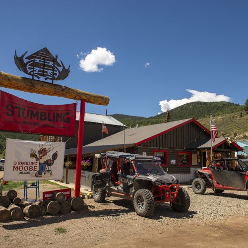 ATVs are parked outside a business in Pitkin, Colorado on a sunny summer day.