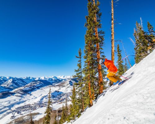 A person skis down a steep slope. Crested Butte Mountain Resort in Crested Butte, CO is known for steep skiing.