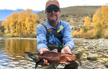 An angler casts into a small lake while fall fishing in Gunnison and Almont.