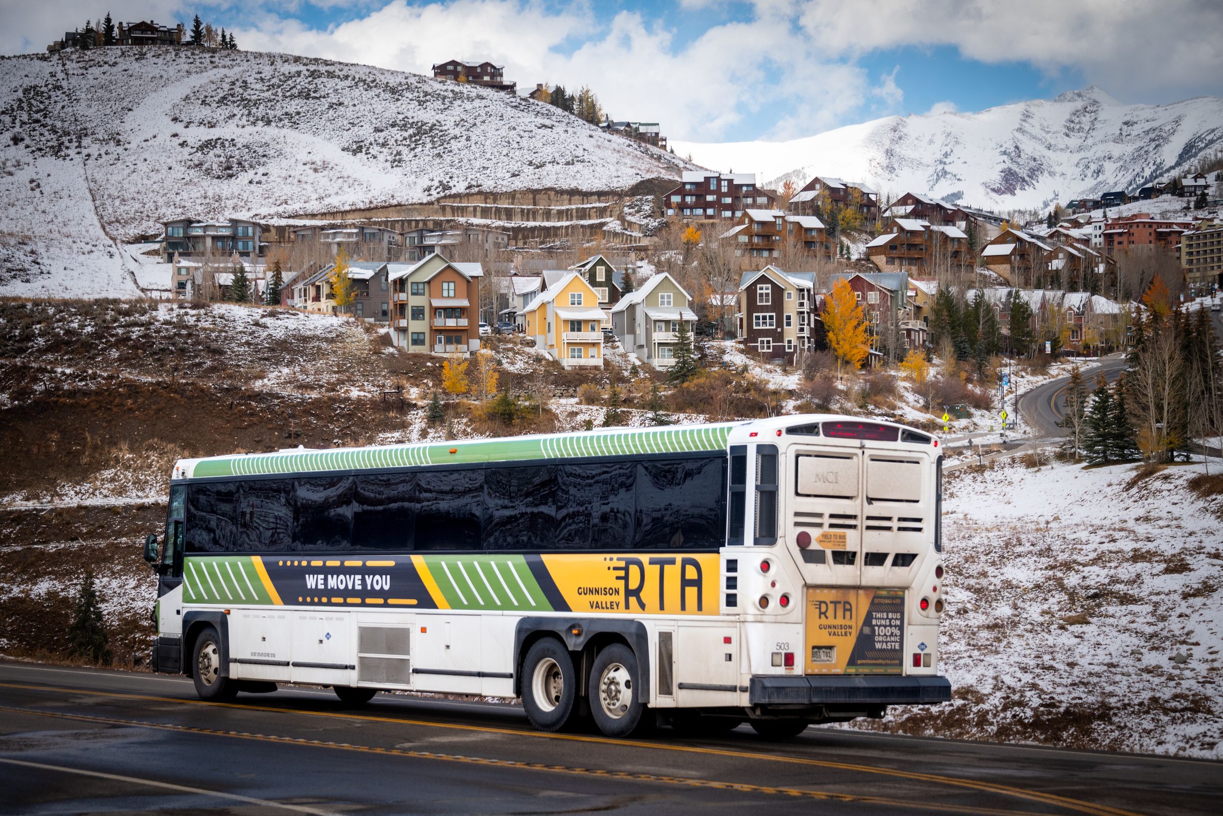 a bus that says RTA driving on a windy road from Gunnison to Crested Butte