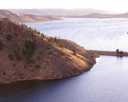 a bridge stretching across a lake at curecanti national recreation area.