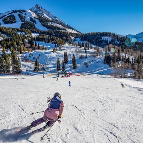 A person skis down a gentle slope. Painter Boy lift serves mostly easy terrain at Crested Butte Mountain Resort.