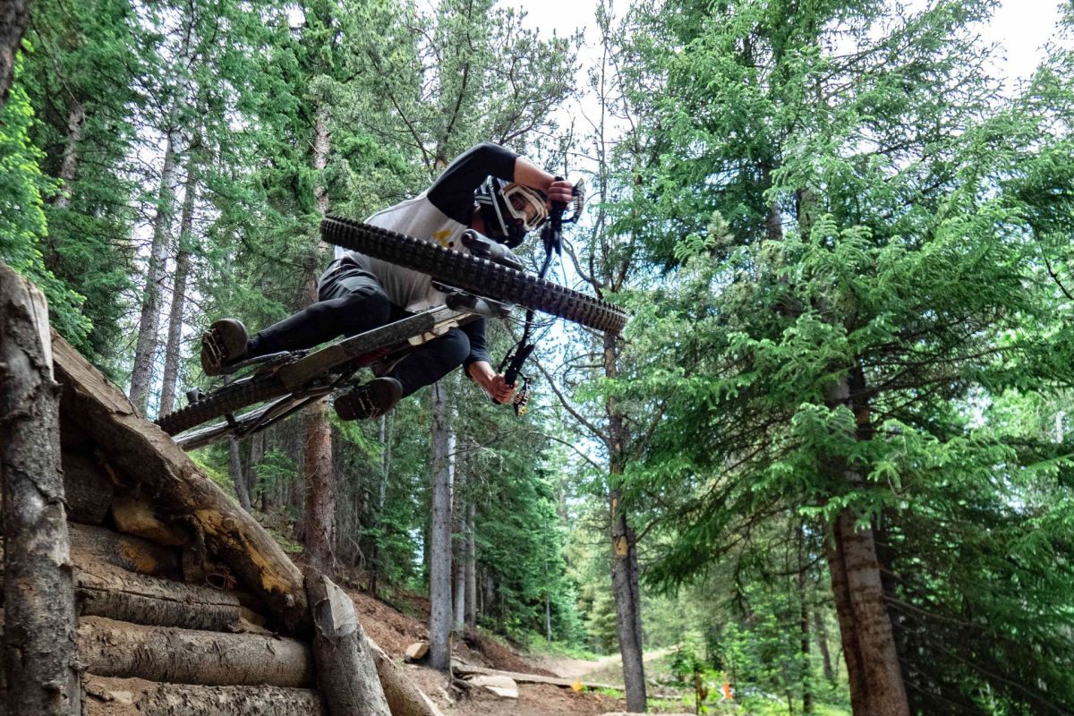 A mountain biker in a full-face helmet rides through a rock garden on the Crested Butte Mountain Bike Park Trails.