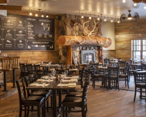 Elk Ave Prime in Crested Butte, CO. The restaurant has a cozy feeling with many tables and chairs.