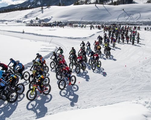 A group of racers competes in Fat Bike Worlds on a snowy track in Crested Butte.