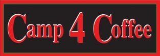Camp 4 Coffee in Crested Butte, CO. The small building has a tall, pointed roof, two doors and license plates on the front of the building. A sign that says "Camp 4 Coffee" resides above the door.
