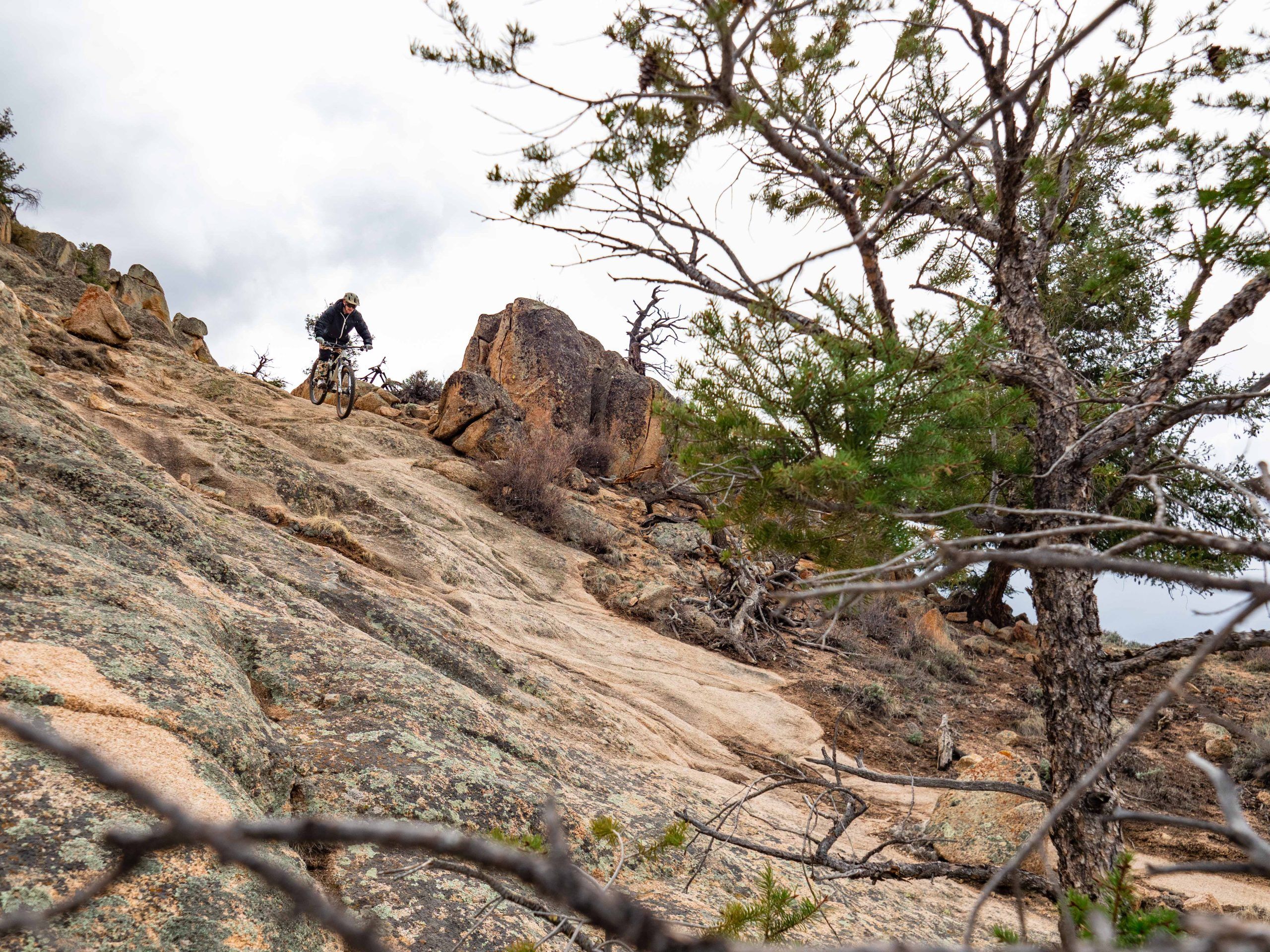 A mountain biker rides down a rocky slope