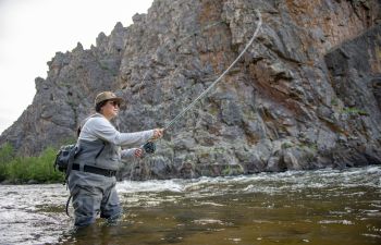 An angler casts into a small lake while fall fishing in Gunnison and Almont.