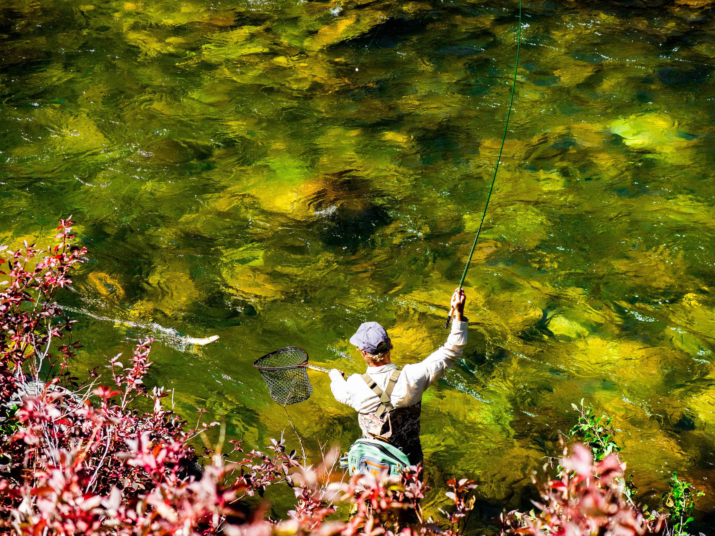 A fly fisherman casting his rod in the river