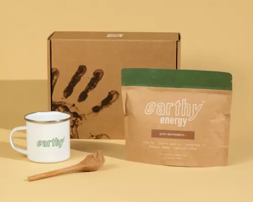 an earthy drink kit with a mug, spoon, box and package of the drink mix