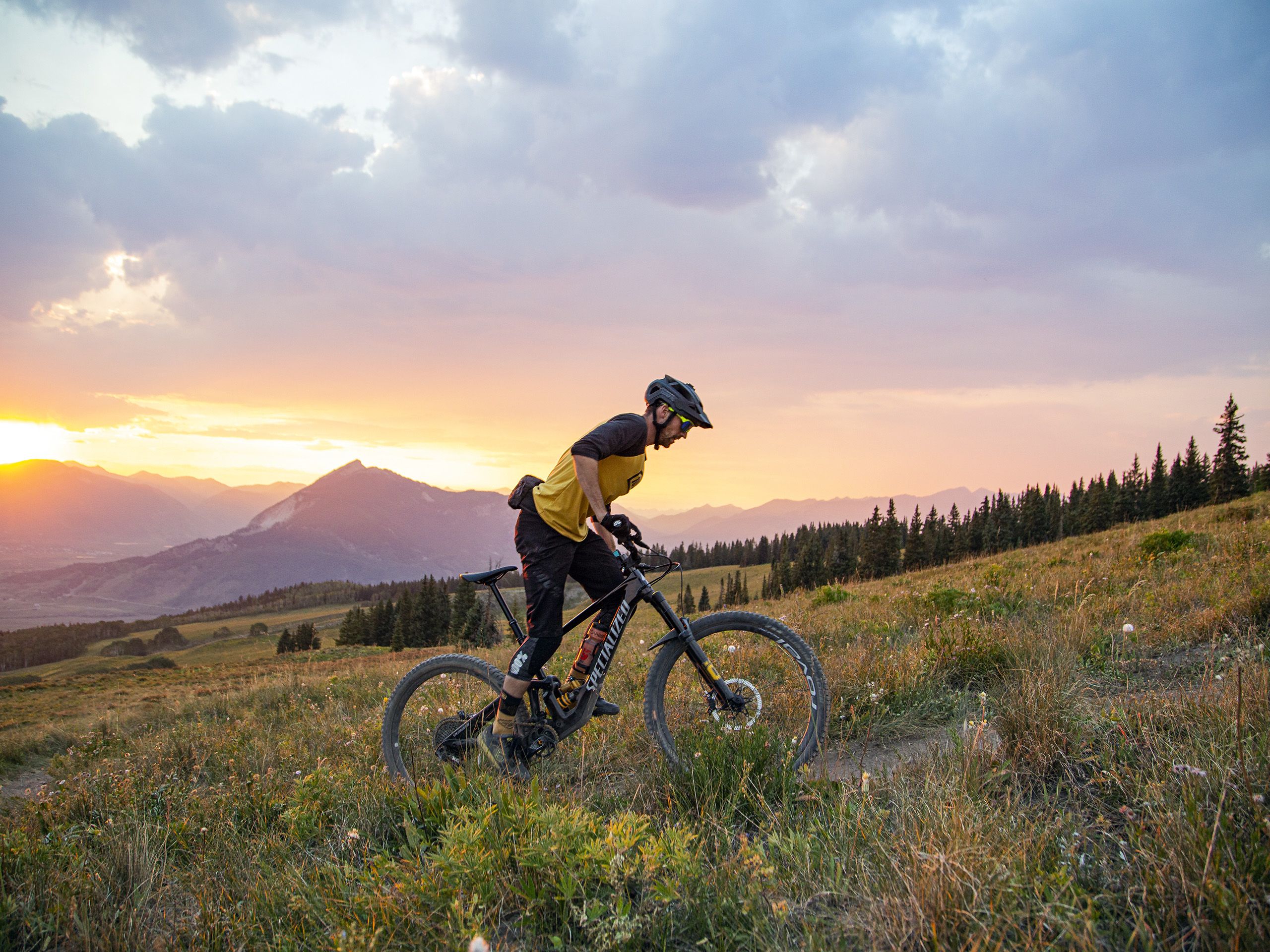 A mountain biker rides Point Lookout trail (one of the Cement Creek trails) at sunset.