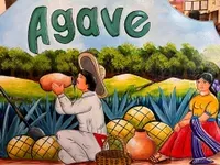 The interior of Agave, a Mexican restaurant in Gunnison, CO. Four stools rest under a bar.