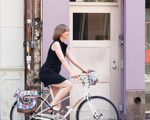 a woman riding a bike with PoCampo bike bags
