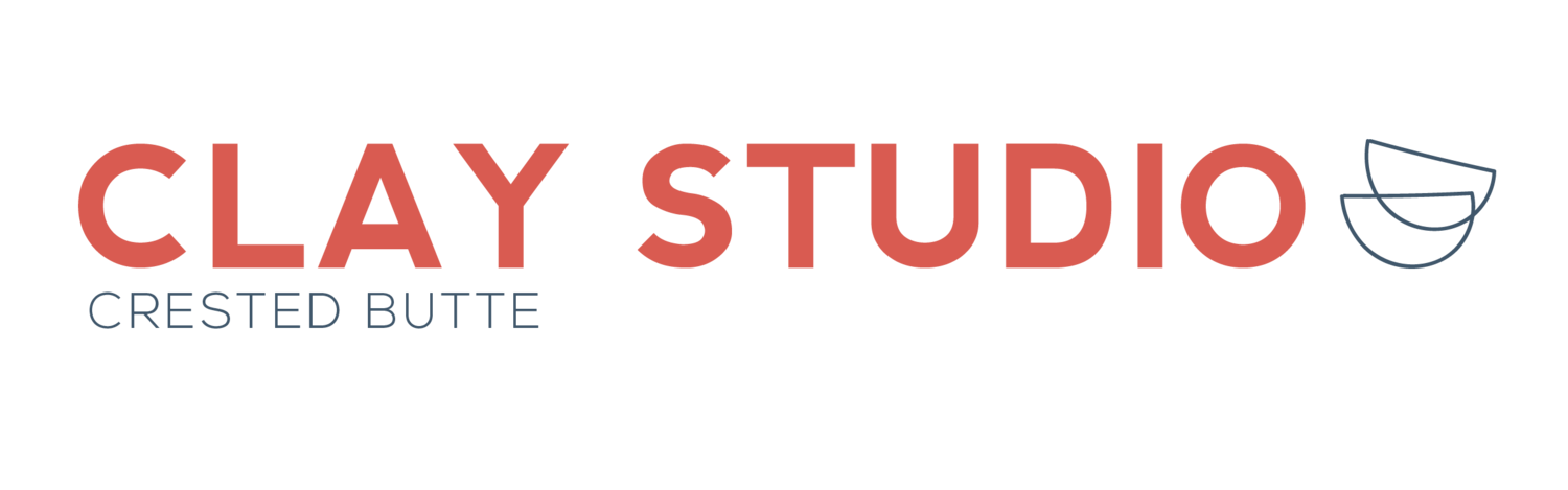 A class at Crested Butte Clay Studio. Six people sit around pottery wheels arranged in a circle.