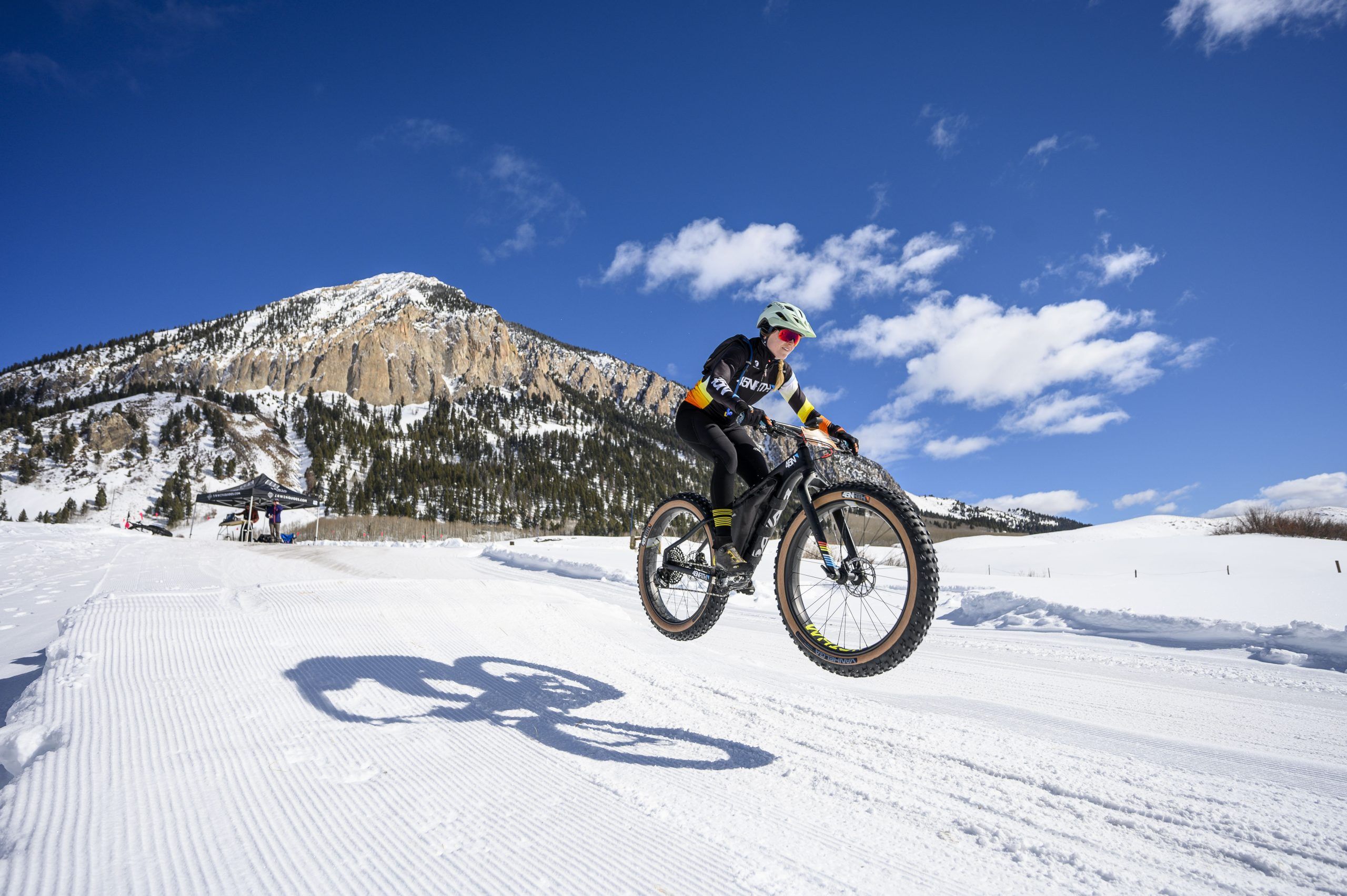 Colorado fat biking on a sunny winter day with a mountain in the background.