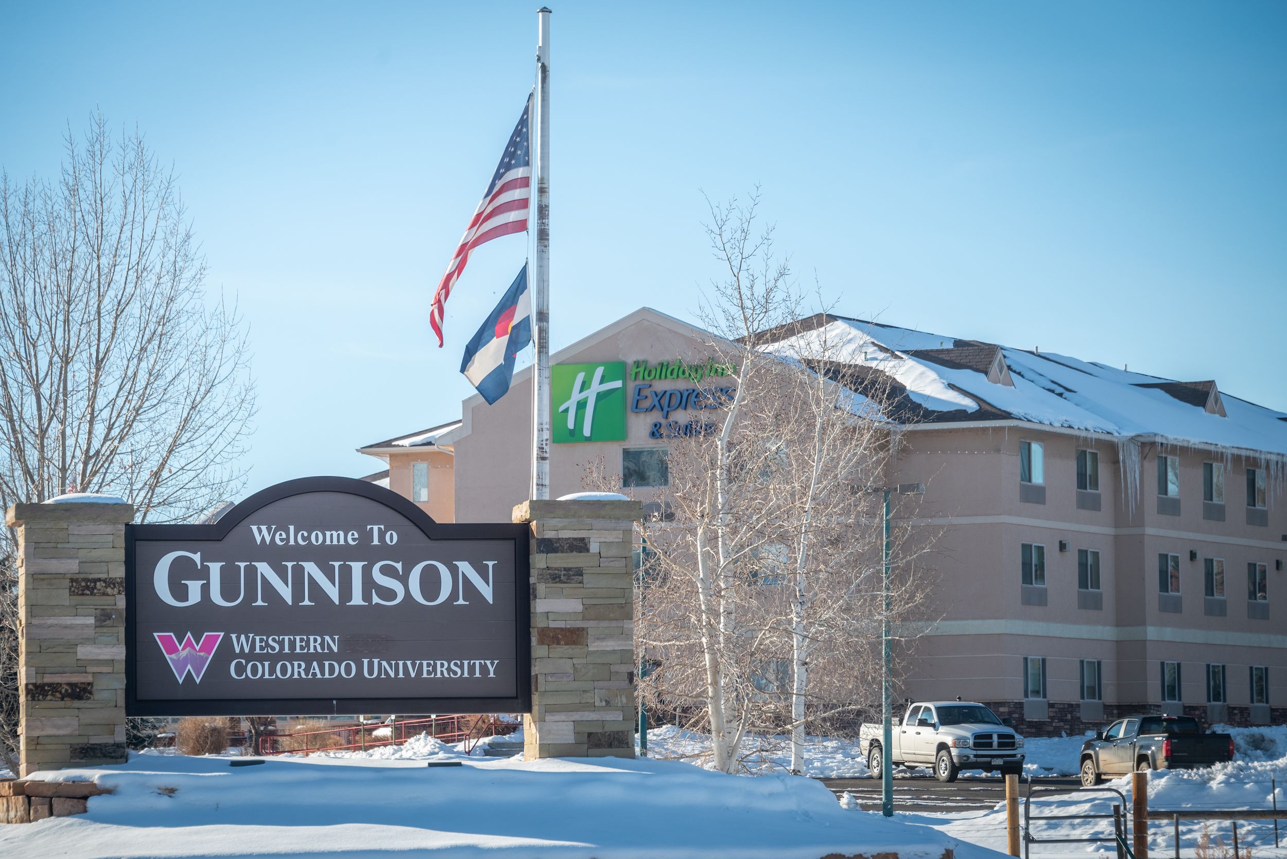 A hotel with a sign that says "Gunnison" in front of it. This is one of the many Gunnison lodging properties