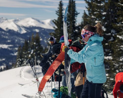 A person taking skins off skis to backcountry ski in Crested Butte.