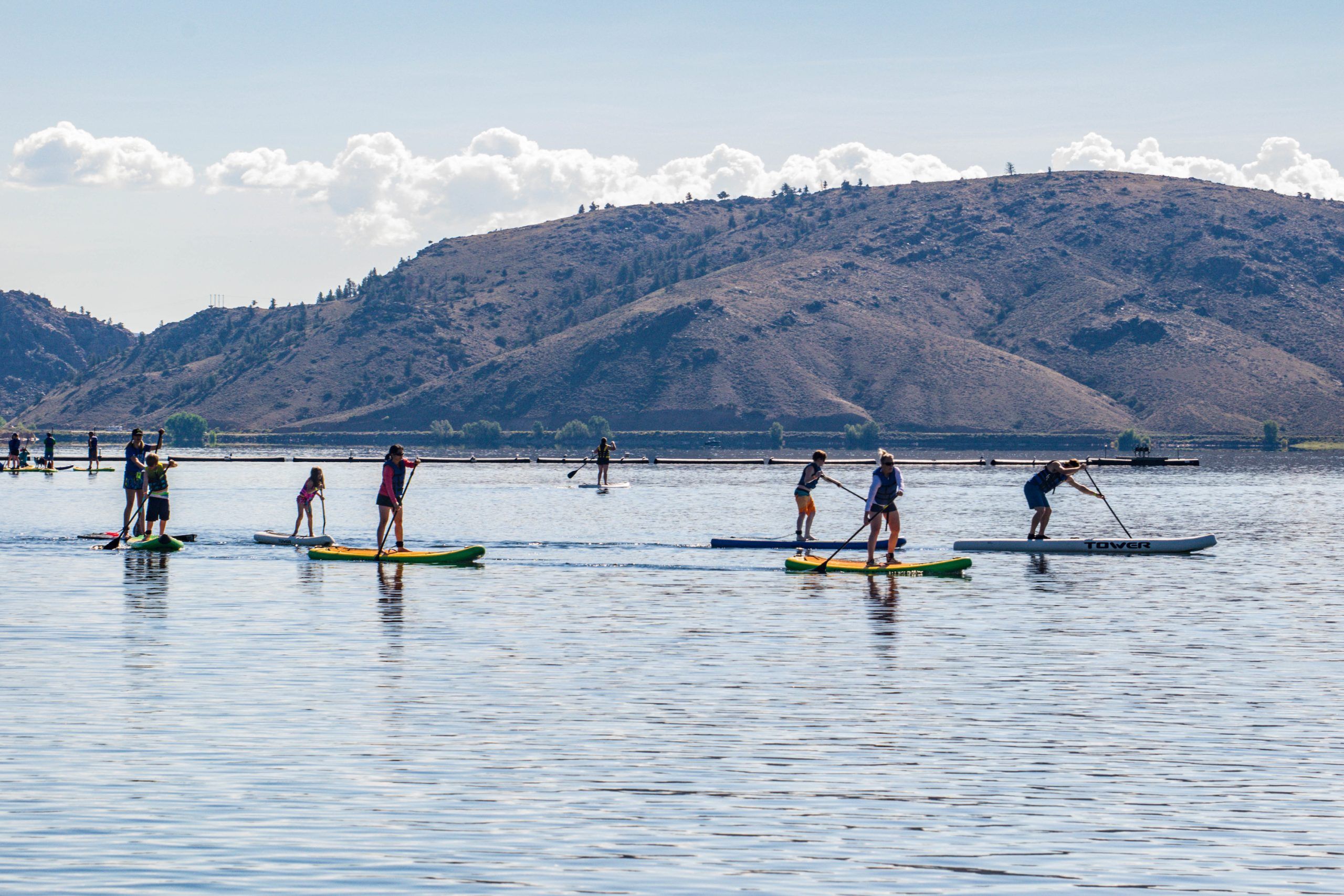 A group of people on stand-up paddle boards on a lake SUP on Blue Mesa Colorado