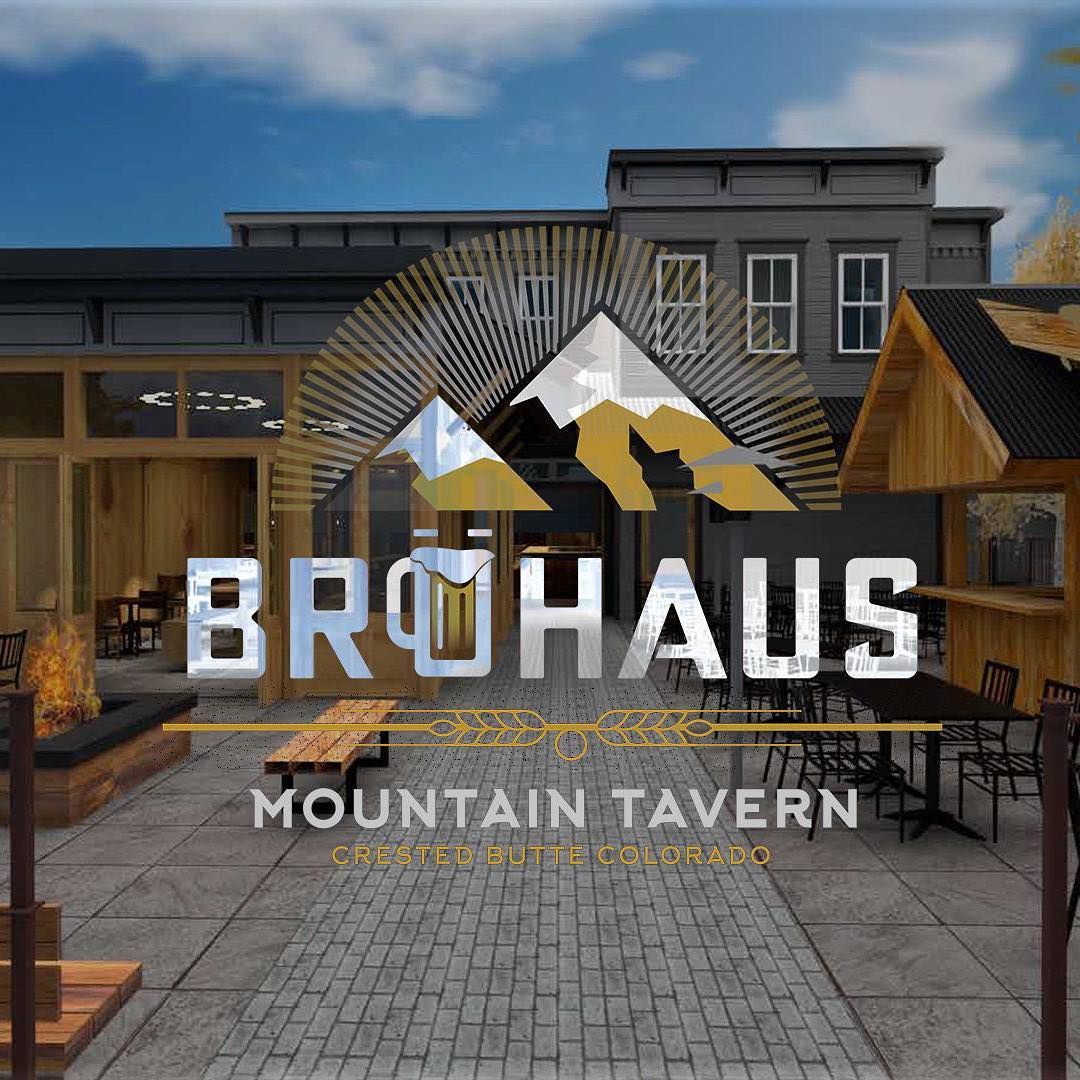 the interior of Bruhaus Crested Butte. Men and women sit at high and low top tables while talking. Barrels line the walls. A light feature with round fixtures hangs from the ceiling.