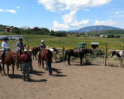 People sit on horseback in a corral waiting for a guided ride with Fantasy Ranch Horseback Adventures.