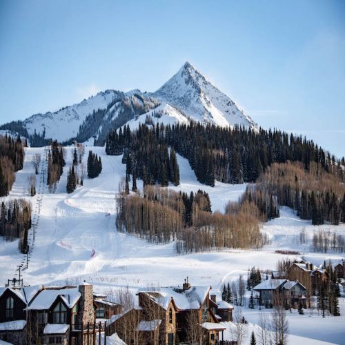 A view of a snowy Crested Butte with a lift from the ski area.