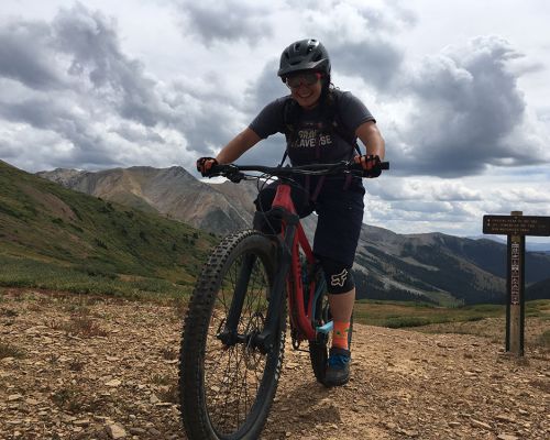 photograph showing Mel reaching the top of a climb on her mountain bike