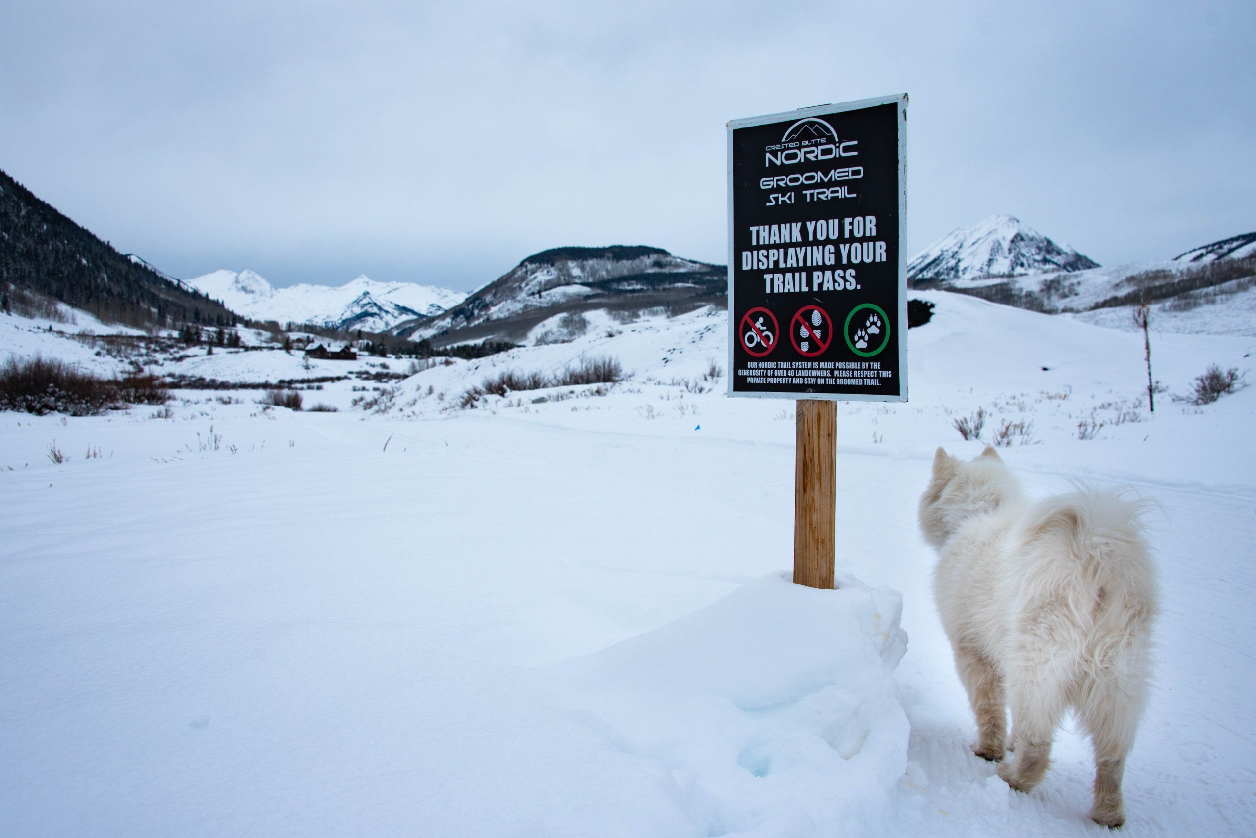 A trail sign at the Crested Butte Nordic Center in Crested Butte, Colorado explains that a trail pass is needed to ski the trails.