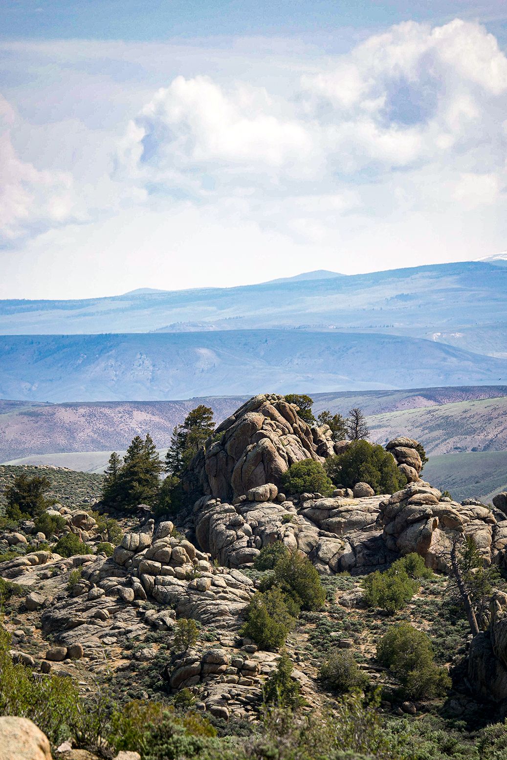 Granite rock formations with blue mountain ridges in the background.