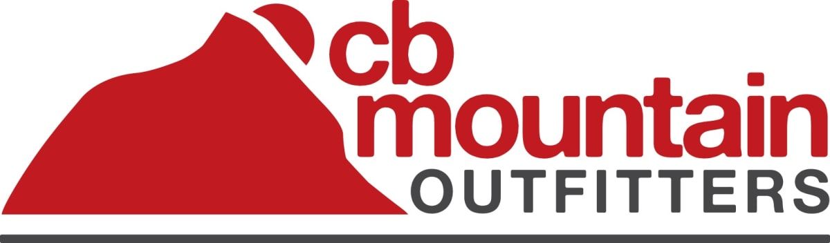 Snowboards and skis lined up in front of a snowbank at cb mountain outfitters