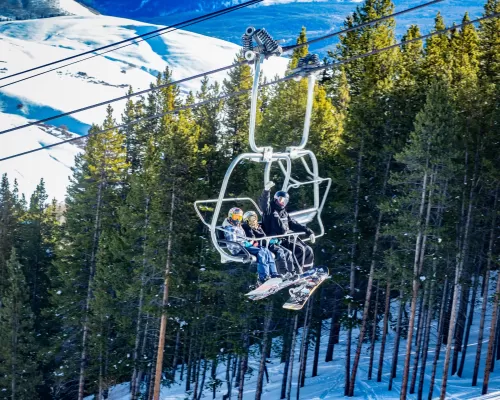 Snowboarders riding the East River Express Lift at Crested Butte Mountain Resort.