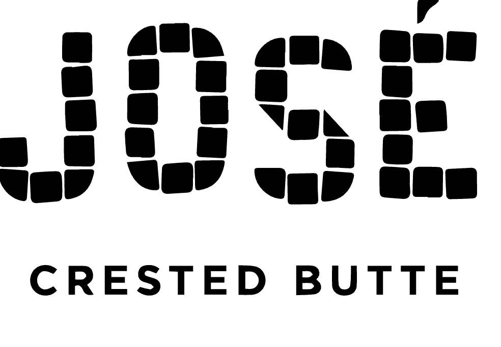 The Elevation Resort outdoor bar. Patio furniture with a mountain peak in the background next to a bar