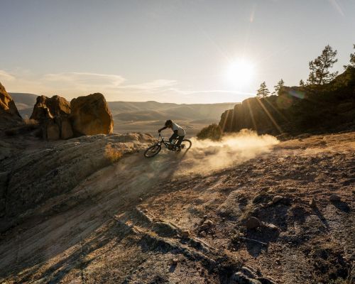 A man mountain bikes on a dusty trail at Hartman Rocks in Gunnison, Colorado.