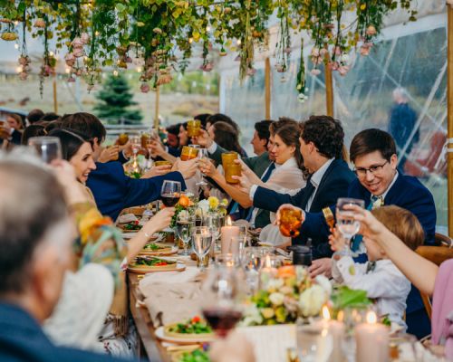 A small group of people sit around a table eating. Celebrate your wedding in Crested Butte with the help of Crested Butte's Personal Chefs