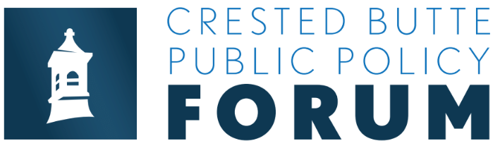 crested butte public policy forum talk. people sit in a theater while someone speaks from a podium on a stage.