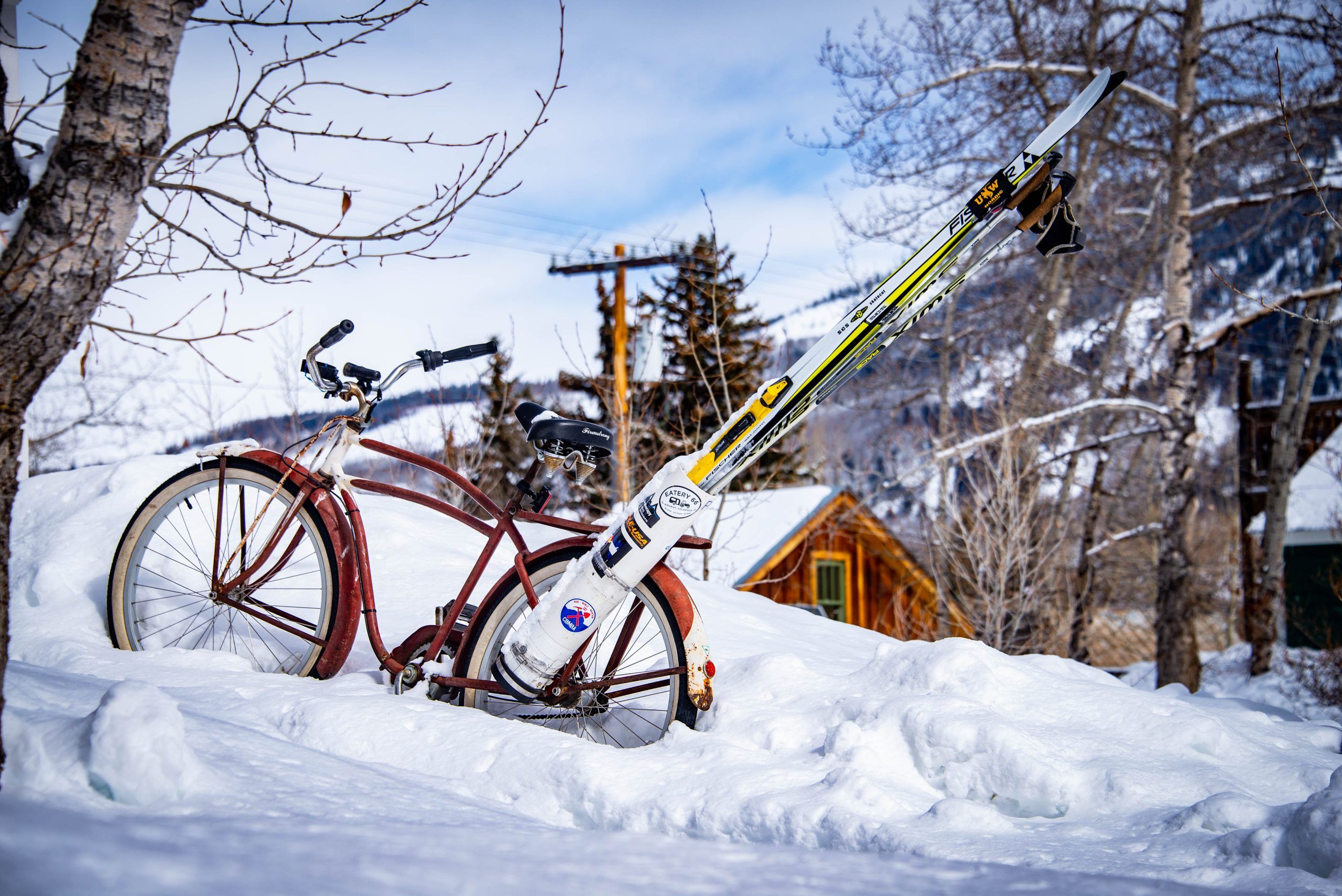 A townie bike carrying cross-country skis is stuck in a snowdrift.