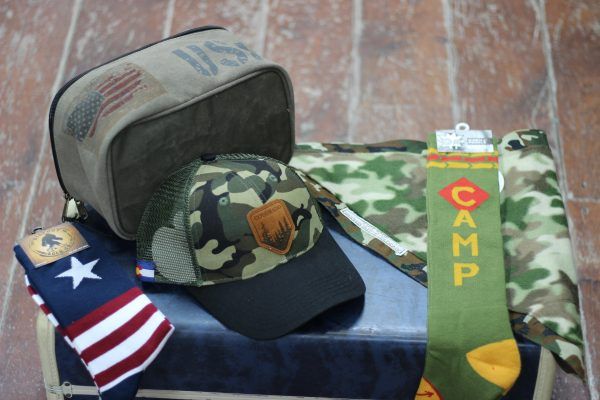 A sign that reads "Alley Hats" with two arrows and a line drawing of a top height. The sign is pointing towards the shop window and door.