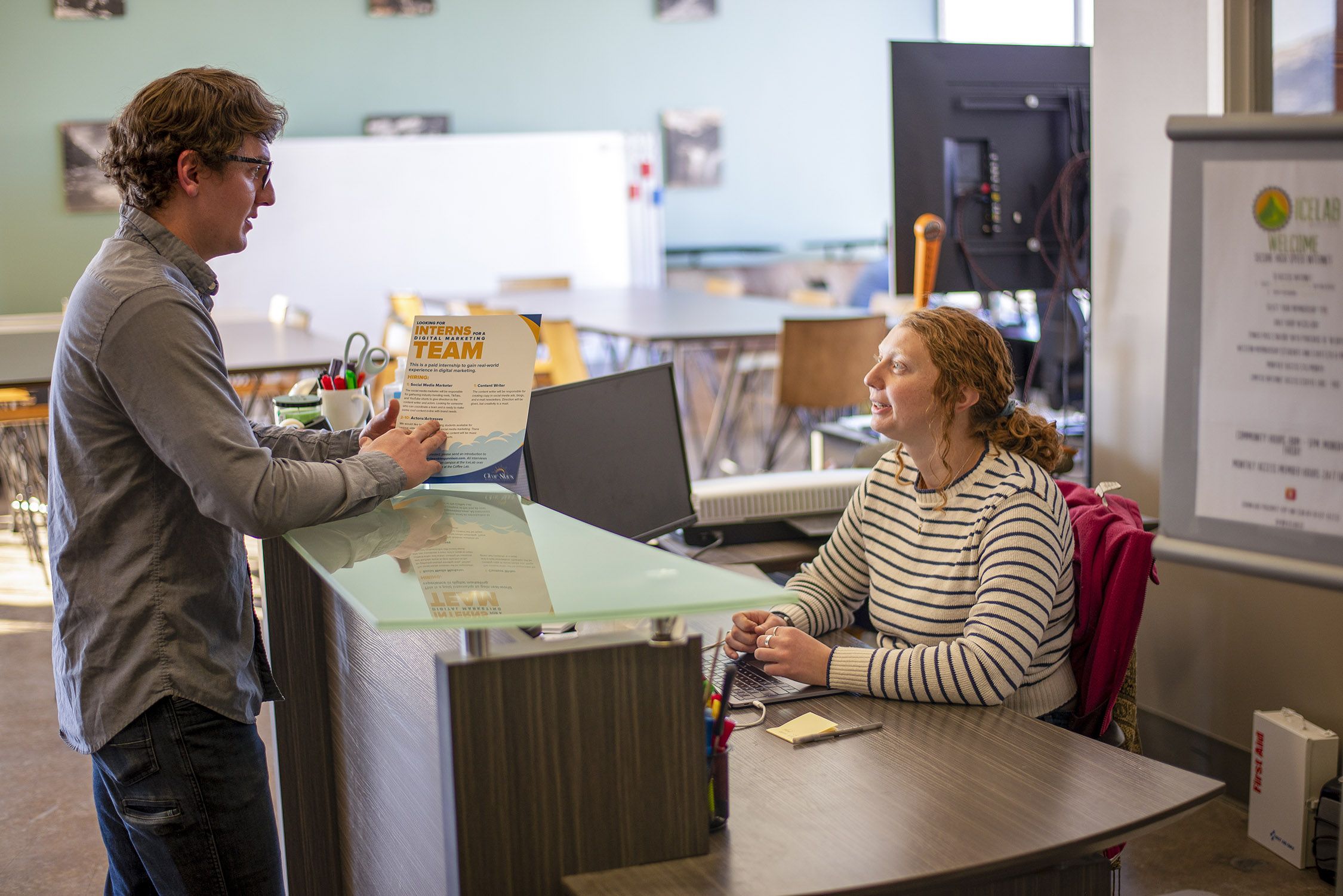 Two people talk about business startups in the Gunnison Valley at a desk in the ICELab