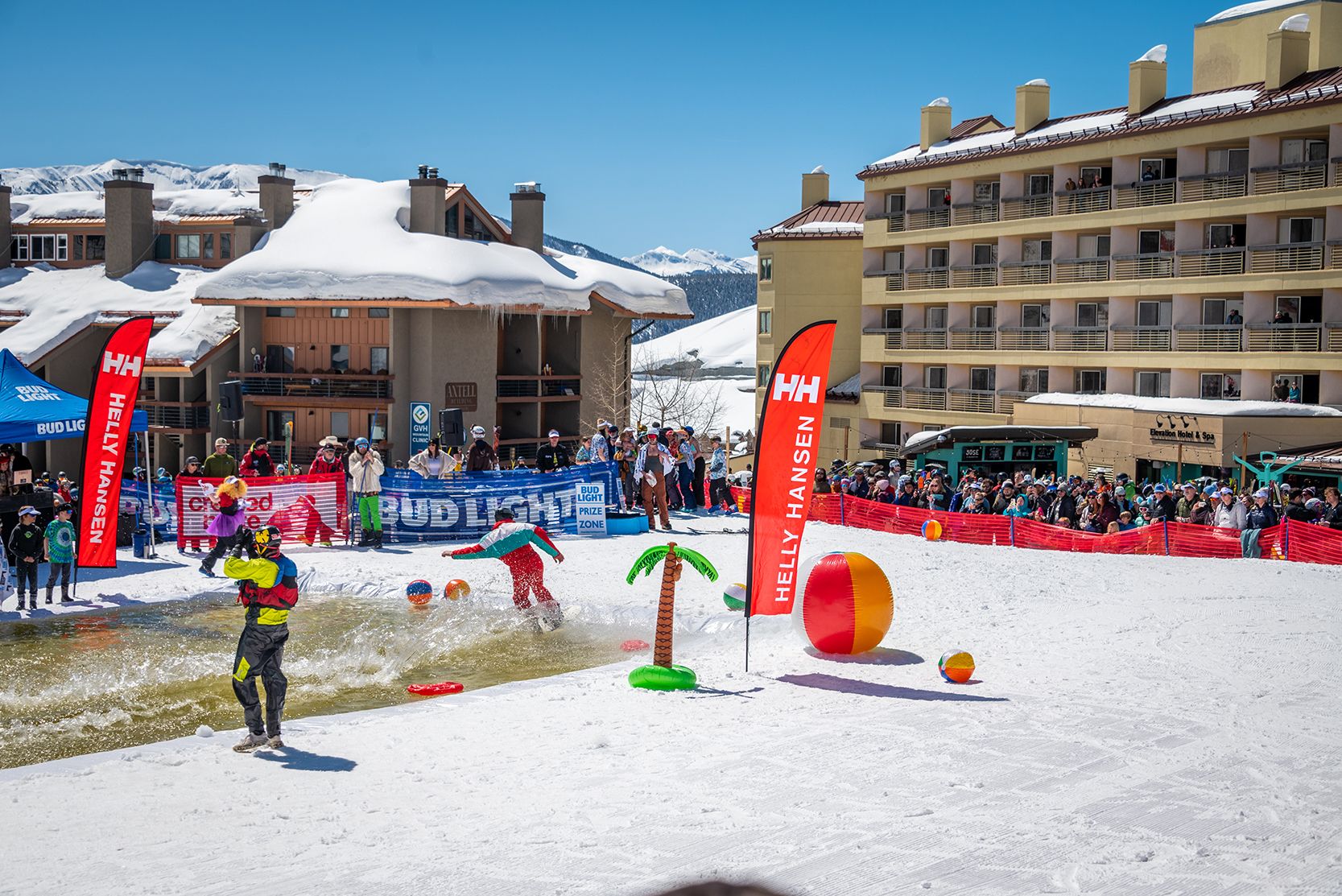 A snowboarder skims across the pond at Crested Butte on a sunny closing day.