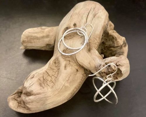 cottonwood tees crested butte. Silver jewelry sold at Cottonwood Tees rest on a piece of driftwood.