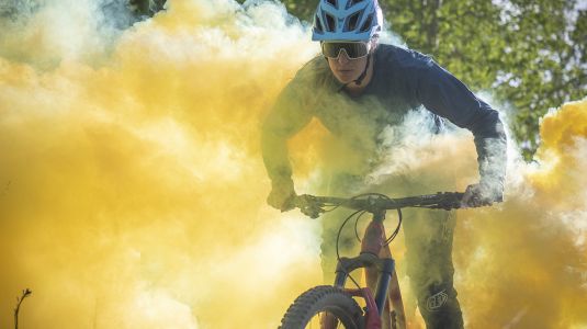Micayla Gatto rides her mountain bike through yellow smoke in "Micayla in Wonderland."