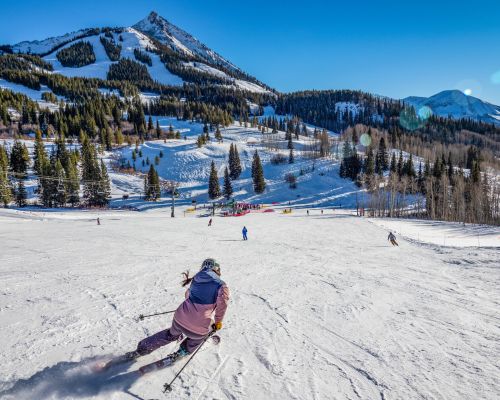 A person skis down a gentle slope. Painter Boy lift serves mostly easy terrain at Crested Butte Mountain Resort.