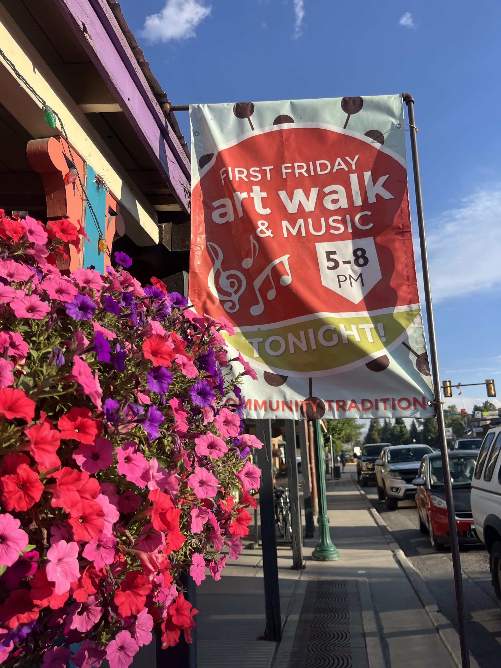 Gunnison Art Walk banner and flowers downtown on a summer day.
