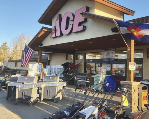 The exterior of Fulmer's Ace Hardware in Gunnison. Lawn mowers and grills are on display in front of the door.