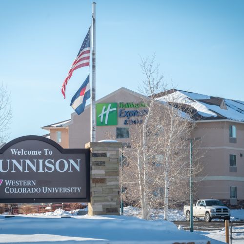 A hotel with a sign that says "Gunnison" in front of it. This is one of the many Gunnison lodging properties 