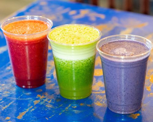 Three smoothies from daily dose in crested butte lined up next to each other at an angle on a table.